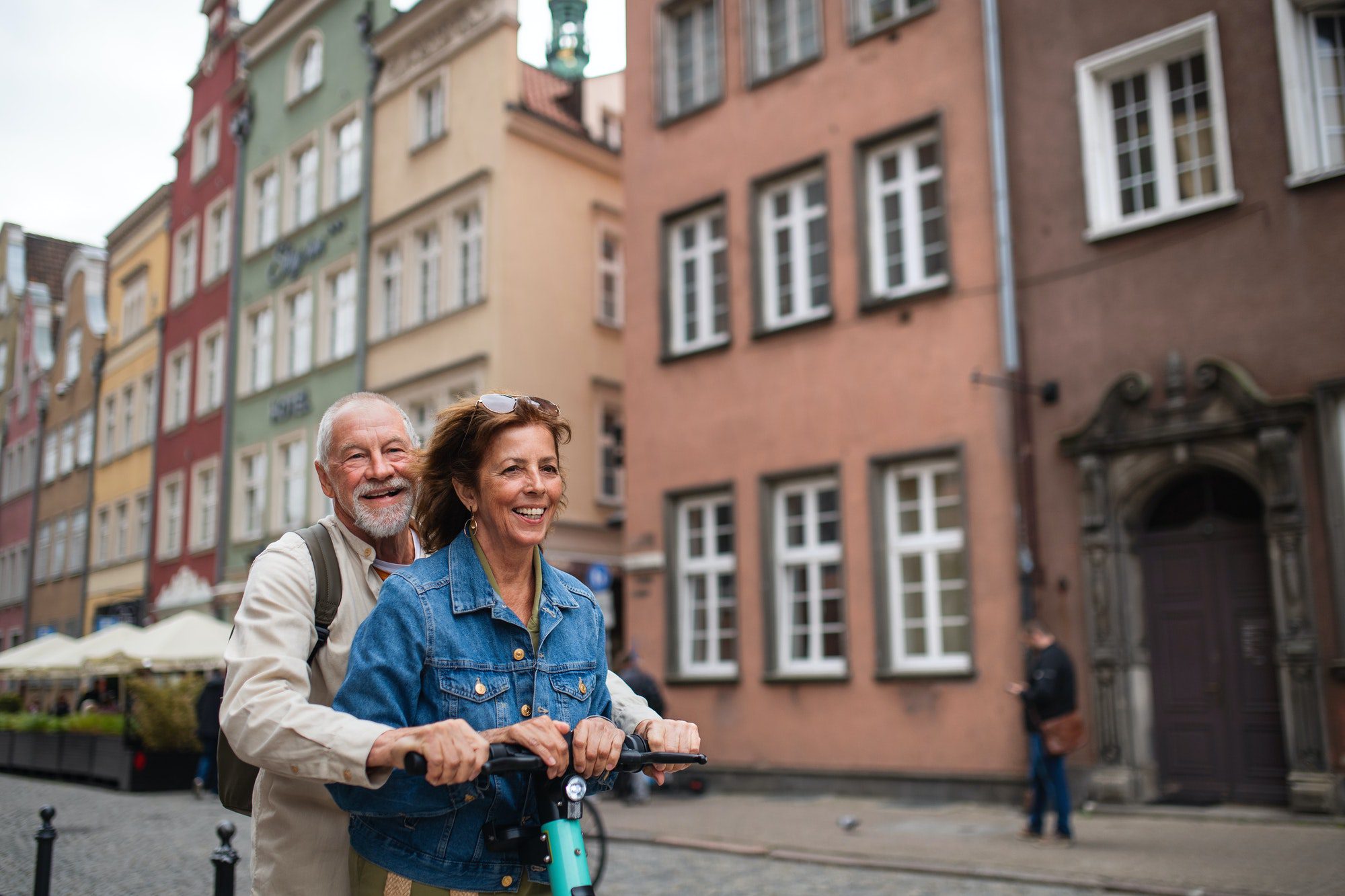 Happy senior couple riding a scooter as they discuss the reasons why Medicare Advantage could be bad.