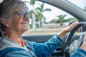 Happy senior woman driving as she thinks about what she needs to know about Medicare Supplements.