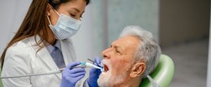 Senior man with dental coverage at dentist`s office